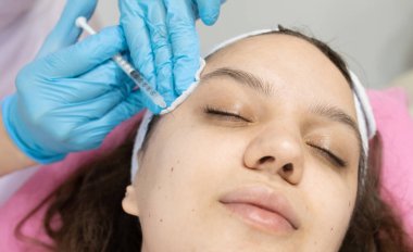 Güzel bir kadının kozmetoloji salonunda iğne olurken yakın plan çekimi..              