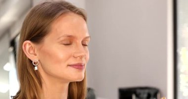 Makyaj sanatçısının yakın plan görüntüsü krem makyaj vakfı uygulaması yetişkin kadın yüzünü güzellik salonunda fırçalamak.           