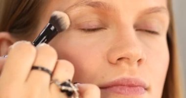 Makyaj sanatçısı güzellik salonunda çalışıyor. Profesyonel makyaj ustası tarafından uygulanan kadın portresi.       