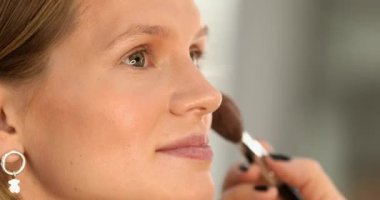 Makyaj sanatçısının yakın plan görüntüsü krem makyaj vakfı uygulaması yetişkin kadın yüzünü güzellik salonunda fırçalamak.           