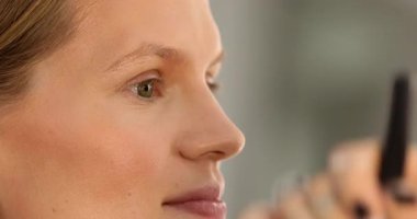 Makyaj sanatçısının yakın plan görüntüsü krem makyaj vakfı uygulaması yetişkin kadın yüzünü güzellik salonunda fırçalamak.           