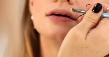 Makyaj sanatçısı güzellik salonunda çalışıyor. Profesyonel makyaj ustası tarafından uygulanan kadın portresi.       