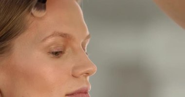 Makyaj sanatçısı güzellik salonunda çalışıyor. Profesyonel makyaj ustası tarafından uygulanan kadın portresi.       