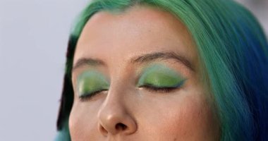 Parlak makyaj yapma süreci. Makyöz yüzüne makyaj yapan bir makyöz. Güzellik salonundaki genç yeşil saçlı kadının portresi..                        