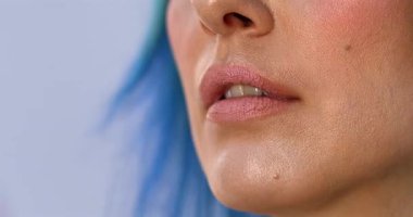 Güzellik salonundaki güzel kız modelin dudaklarına makyaj yapan profesyonel makyözün yakın plan görüntüsü.                 