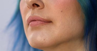 Güzellik salonundaki güzel kız modelin dudaklarına makyaj yapan profesyonel makyözün yakın plan görüntüsü.                 