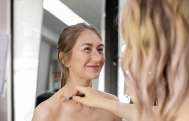 Profesyonel makyöz güzellik salonundaki güzel bayan modellere makyaj yapıyor..                       