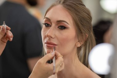 Profesyonel makyöz güzellik salonundaki güzel bayan modellere makyaj yapıyor..                       
