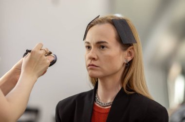 Makyaj sanatçısı genç ve güzel bir kadınla profesyonel makyaj yapıyor..        