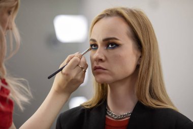 Güzel bir kadına göz farı süren makyaj stilistinin yakın plan görüntüsü 