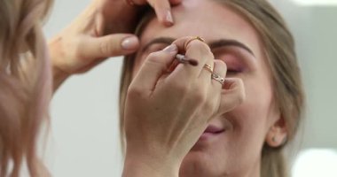 Profesyonel makyöz güzellik salonundaki güzel bayan modellere makyaj yapıyor..                       