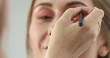 Profesyonel makyöz güzellik salonundaki güzel bayan modellere makyaj yapıyor..                       