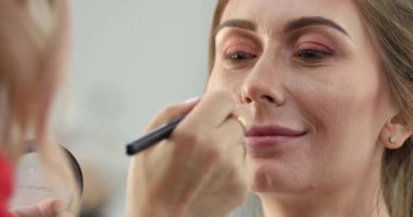 Profesyonel makyöz güzellik salonundaki güzel bayan modellere makyaj yapıyor..                       