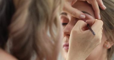 Profesyonel makyöz güzellik salonundaki güzel bayan modellere makyaj yapıyor..                       