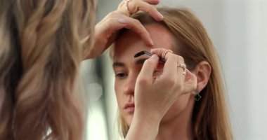 Profesyonel makyöz güzellik salonundaki güzel bayan modellere makyaj yapıyor..               