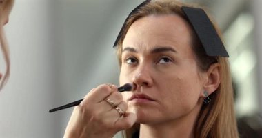 Profesyonel makyöz güzellik salonundaki güzel bayan modellere makyaj yapıyor..               