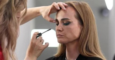 Profesyonel makyöz güzellik salonundaki güzel bayan modellere makyaj yapıyor..               