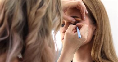 Profesyonel makyöz güzellik salonundaki güzel bayan modellere makyaj yapıyor..               