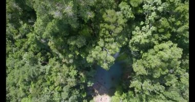 Büyük bir su kütlesi içinde yüzen bir grup insan. Su berrak ve mavi, hava manzaralı.