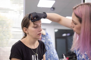 Profesyonel makyöz güzellik salonundaki güzel bayan modellere makyaj yapıyor..                   