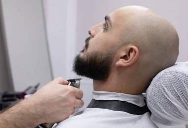 Berber dükkanındaki müşterisinde sakallı profesyonel berber.                     