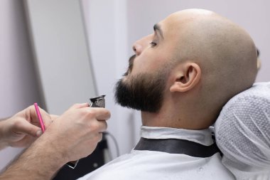 Berber dükkanındaki müşterisinde sakallı profesyonel berber.                     