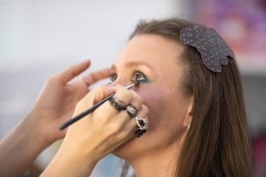 Profesyonel makyöz güzellik salonundaki güzel bayan modellere makyaj yapıyor..     