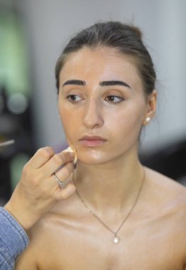 Profesyonel makyöz güzellik salonundaki güzel bayan modellere makyaj yapıyor..               