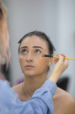 Profesyonel makyöz güzellik salonundaki güzel bayan modellere makyaj yapıyor..               