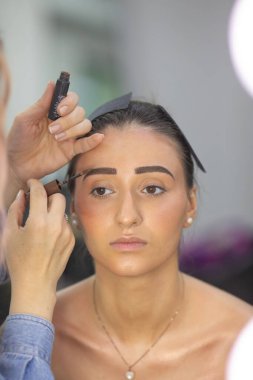 Profesyonel makyöz güzellik salonundaki güzel bayan modellere makyaj yapıyor..               