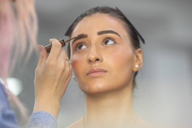 Profesyonel makyöz güzellik salonundaki güzel bayan modellere makyaj yapıyor..               