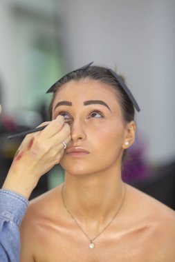 Profesyonel makyöz güzellik salonundaki güzel bayan modellere makyaj yapıyor..               