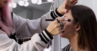 Profesyonel makyöz güzellik salonundaki güzel bayan modellere makyaj yapıyor..     