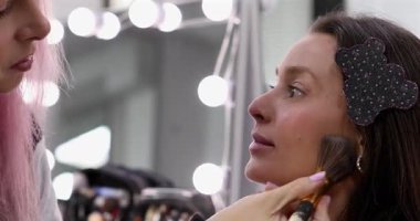 Profesyonel makyöz güzellik salonundaki güzel bayan modellere makyaj yapıyor..     