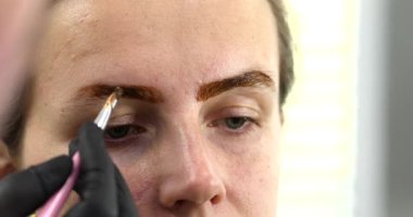 Güzellik salonunda güzel bir genç kadının portresi, kaş makyajı yaptırıyor..                          