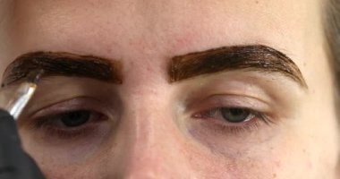 Güzellik salonunda güzel bir genç kadının portresi, kaş makyajı yaptırıyor..                          