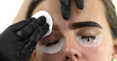 Güzellik salonunda güzel bir genç kadının portresi, kaş makyajı yaptırıyor..                          