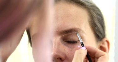 Güzellik salonunda güzel bir genç kadının portresi, kaş makyajı yaptırıyor..                          