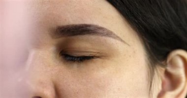 Güzellik salonundaki güzel genç bayanı yakından görmek, kaş makyajı yaptırmak..                          