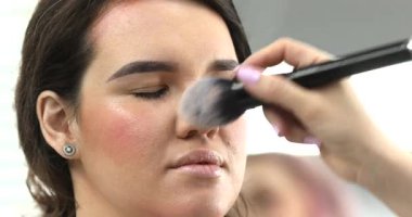 Profesyonel makyöz güzellik salonundaki güzel bayan modellere makyaj yapıyor..                   