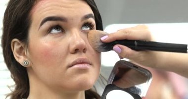 Profesyonel makyöz güzellik salonundaki güzel bayan modellere makyaj yapıyor..                   