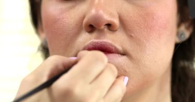 Profesyonel makyöz güzellik salonundaki güzel bayan modellere makyaj yapıyor..                   