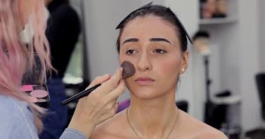 Güzellik salonuna makyaj yaptıran genç bir kadın. Makyaj sanatçısı ve istemci       