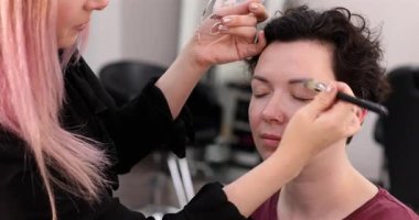 Profesyonel makyöz güzellik salonundaki güzel kadın mankene makyaj yapıyor..                      