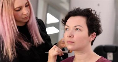 Profesyonel makyöz güzellik salonundaki güzel kadın mankene makyaj yapıyor..                      