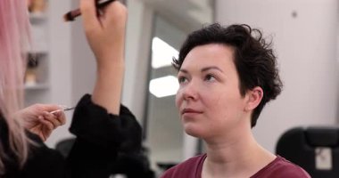 Profesyonel makyöz güzellik salonundaki güzel kadın mankene makyaj yapıyor..                      