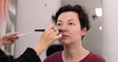 Profesyonel makyöz güzellik salonundaki güzel kadın mankene makyaj yapıyor..                      