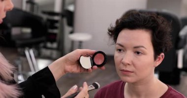 Profesyonel makyöz güzellik salonundaki güzel kadın mankene makyaj yapıyor..                      