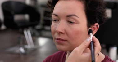 Profesyonel makyöz güzellik salonundaki güzel kadın mankene makyaj yapıyor..                      