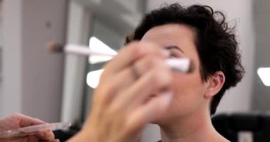 Profesyonel makyöz güzellik salonundaki güzel kadın mankene makyaj yapıyor..                      